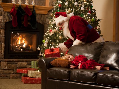 santa claus putting presents under the tree